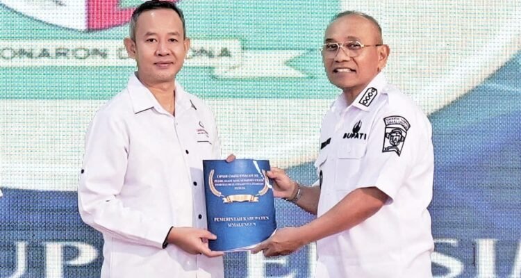 Bupati Simalungun Anton Achmad Saragih (pakai kacamata) menerima hasil laporan penilaian Ombudsman RI di Aula T Rizal Nurdin, Medan, Selasa (24/2/2026). Foto: dokumen Dinas Kominfo Simalungun