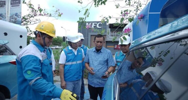 General Manager PLN UID Sumatera Utara, Mundhakir saat berbincang bersama pengemudi taksi mobil listrik yang sedang melakukan pengisian baterai kendaraan