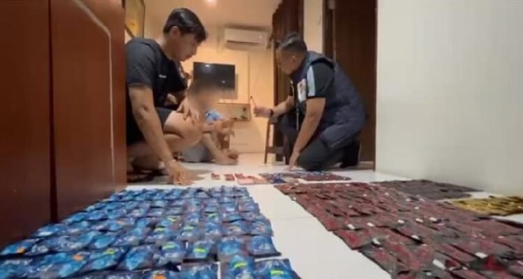Petugas menyita barang bukti di dalam kamar apartemen.