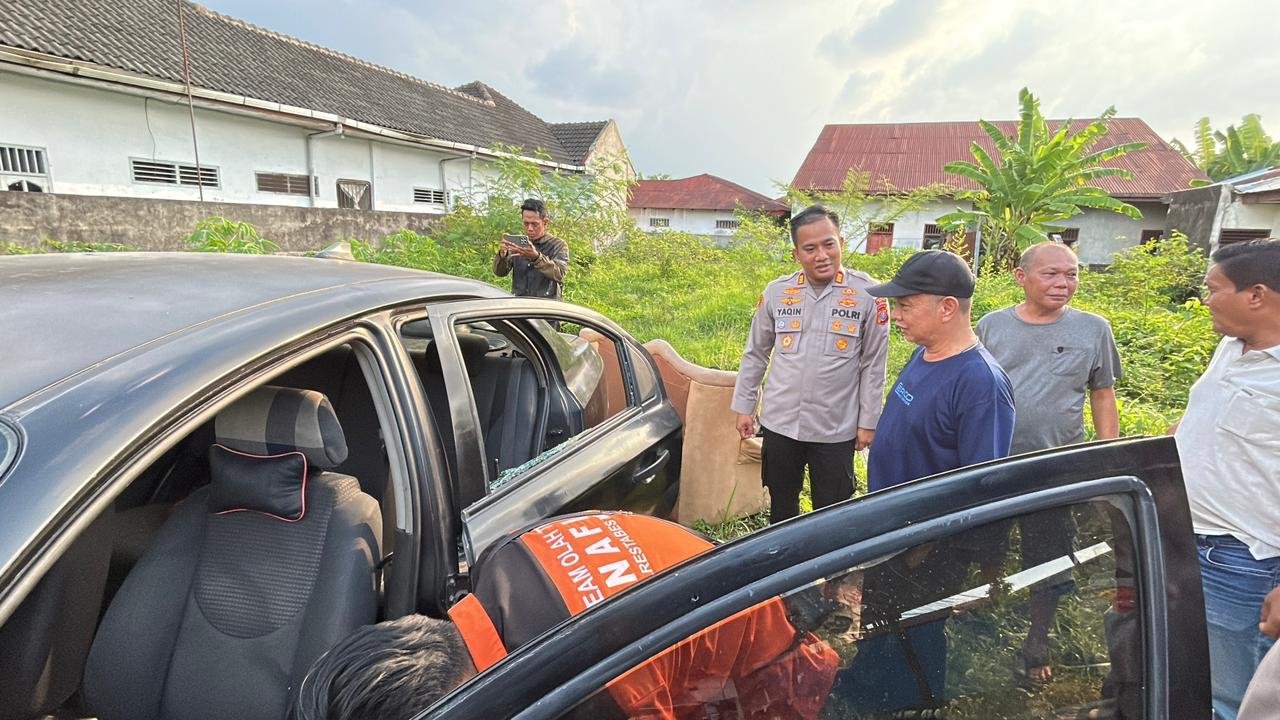 Kapolsek Medan Area, AKP M Ainul Yaqin memeriksa TKP dan mobil tempat penemuan pasutri meninggal dunia di Jalan Harapan Pasti. (Ist)