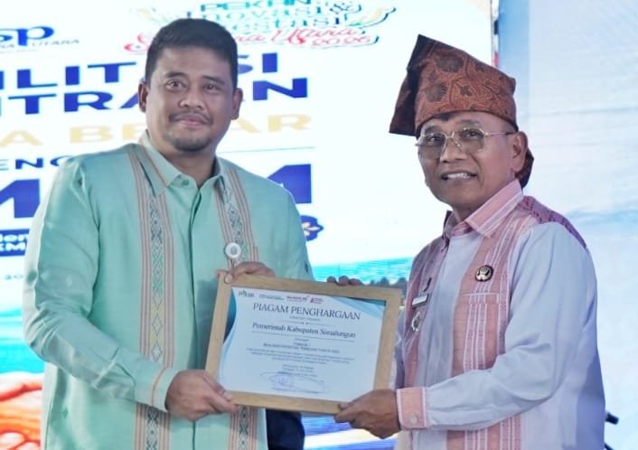 Bupati Simalungun Anton Achmad Saragih saat msnerima penghargaan dari Gubernur Sumut Bobby Afif Nasution. Foto: dokumen Dinas Kominfo Simalungun