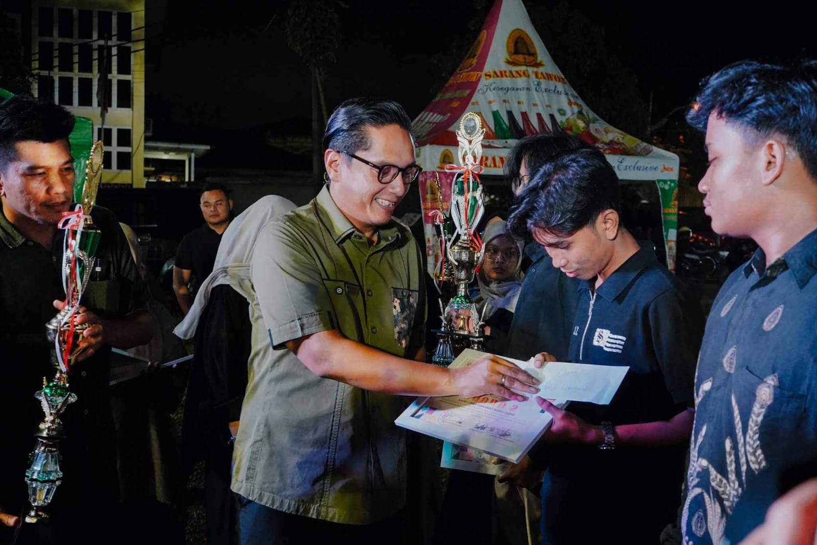 Rico Waas berikan hadiah pada salah seorang mahasiswa pada penutupan IMM Expo. (Kominfo Medan Dok)