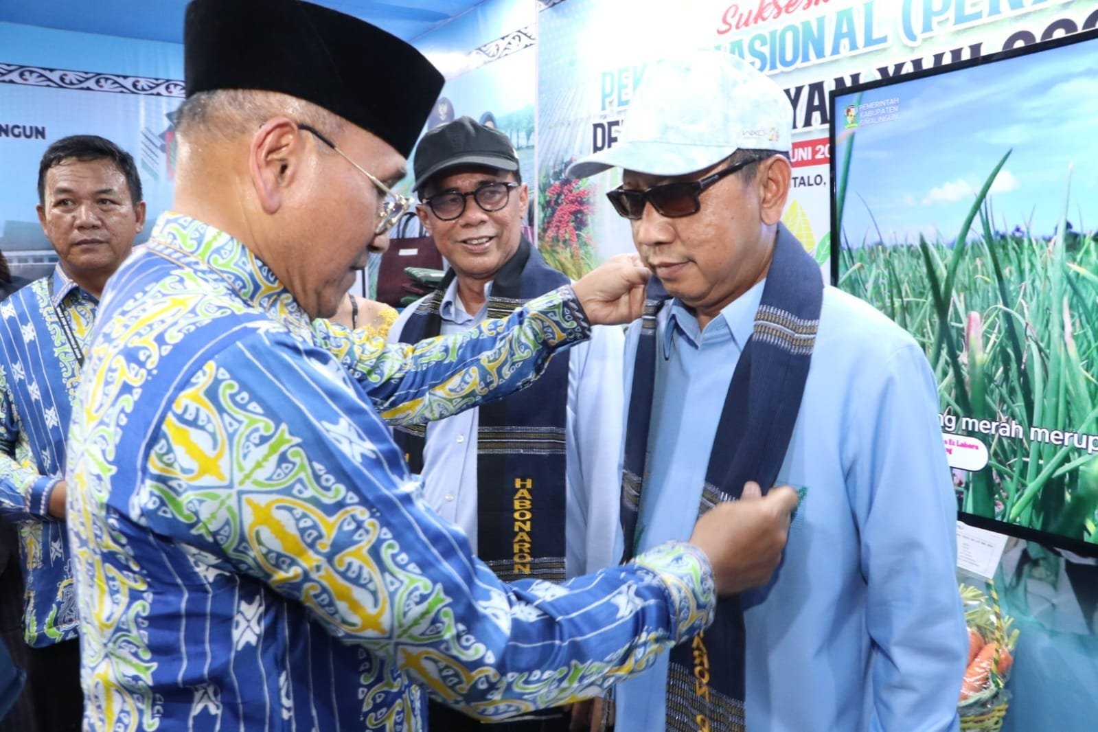 Bupati Simalungun Anton Achmad Saragih menyematkan selempang kepada pengurus Kontak Tani Nelayan Andalan (KTNA) Kabupaten Simalungun yang turut ambil bagian dalam Pekan Nasional (PENAS) Petani Nelayan XVII Tahun 2026 di Kecamatan Limboto, Kabupaten Gorontalo, Sabtu (20/6/2026). Foto: dokumen Dinas Kominfo Simalungun