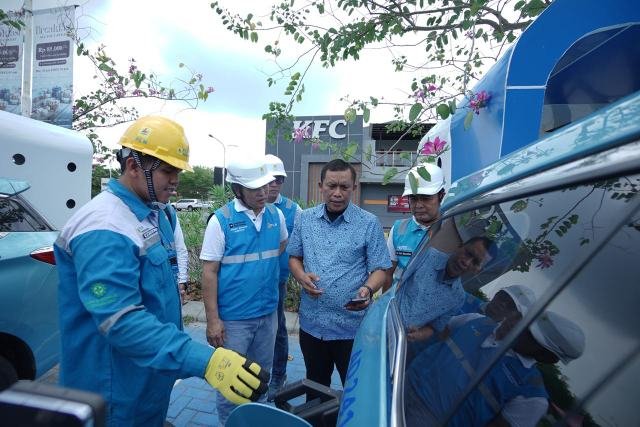 General Manager PLN UID Sumatera Utara, Mundhakir saat berbincang bersama pengemudi taksi mobil listrik yang sedang melakukan pengisian baterai kendaraan